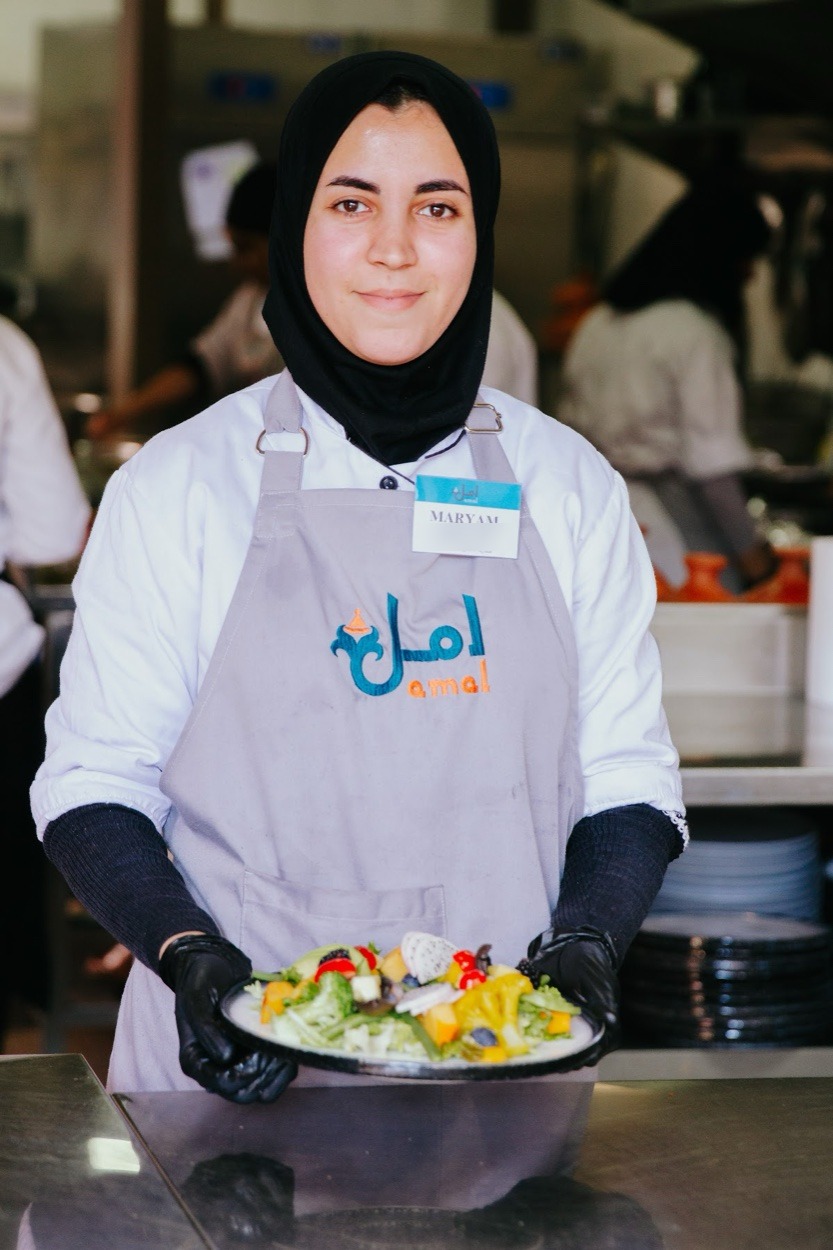 An Amal trainee with a dish she prepared