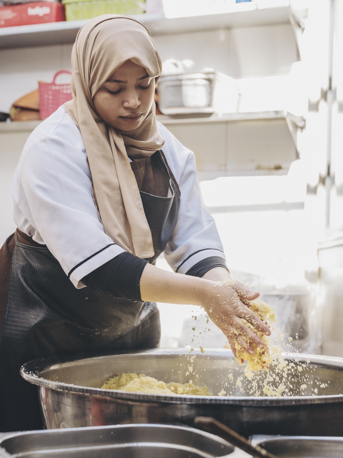 An Amal trainee kneading dough by hand in the training kitchen