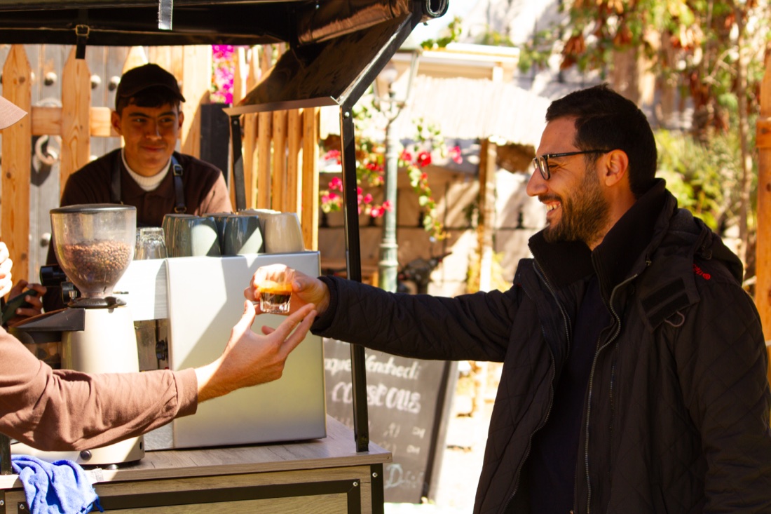 An Amal barista serving coffee at the Coffee Bike
